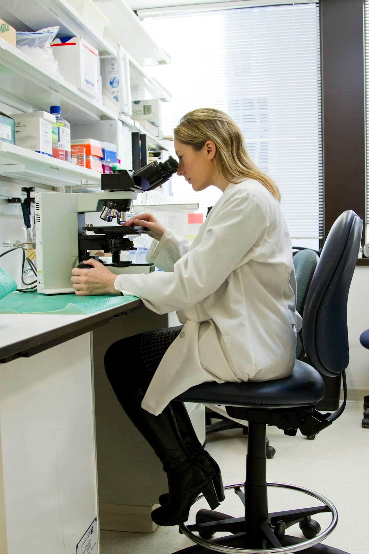 A researcher examining samples through a microscope in a laboratory